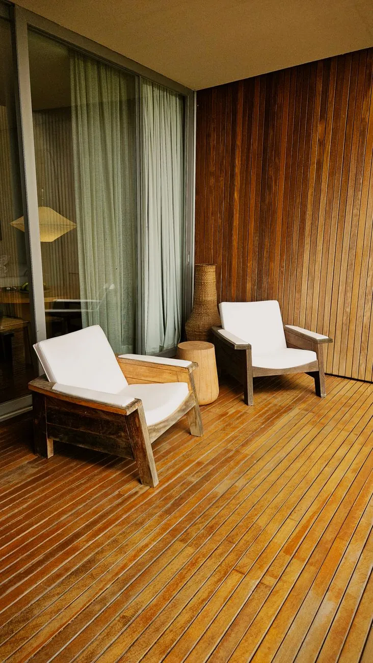 Warm-toned wood deck with two cushioned lounge chairs