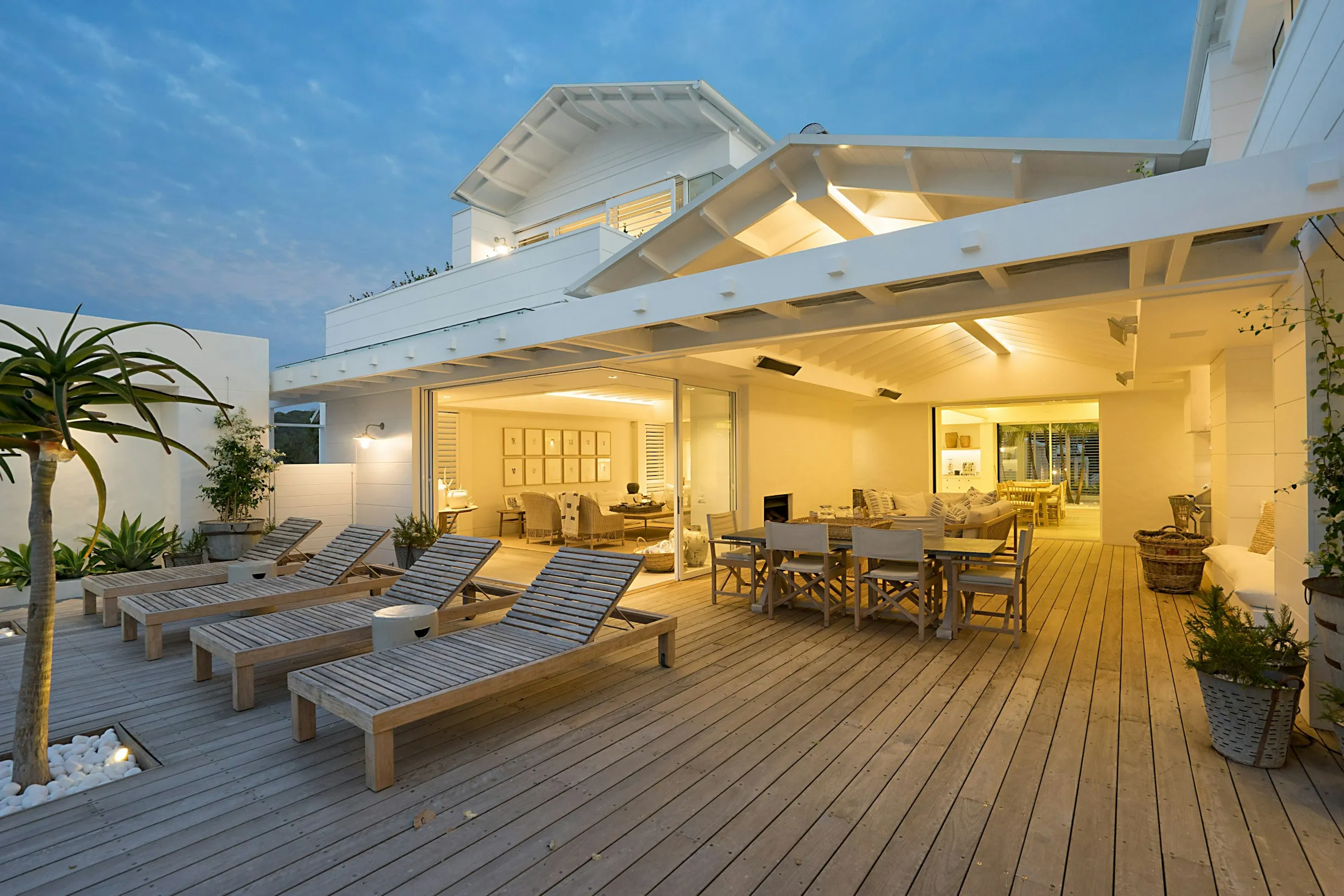 Deck lit at dusk with integrated step and railing lighting